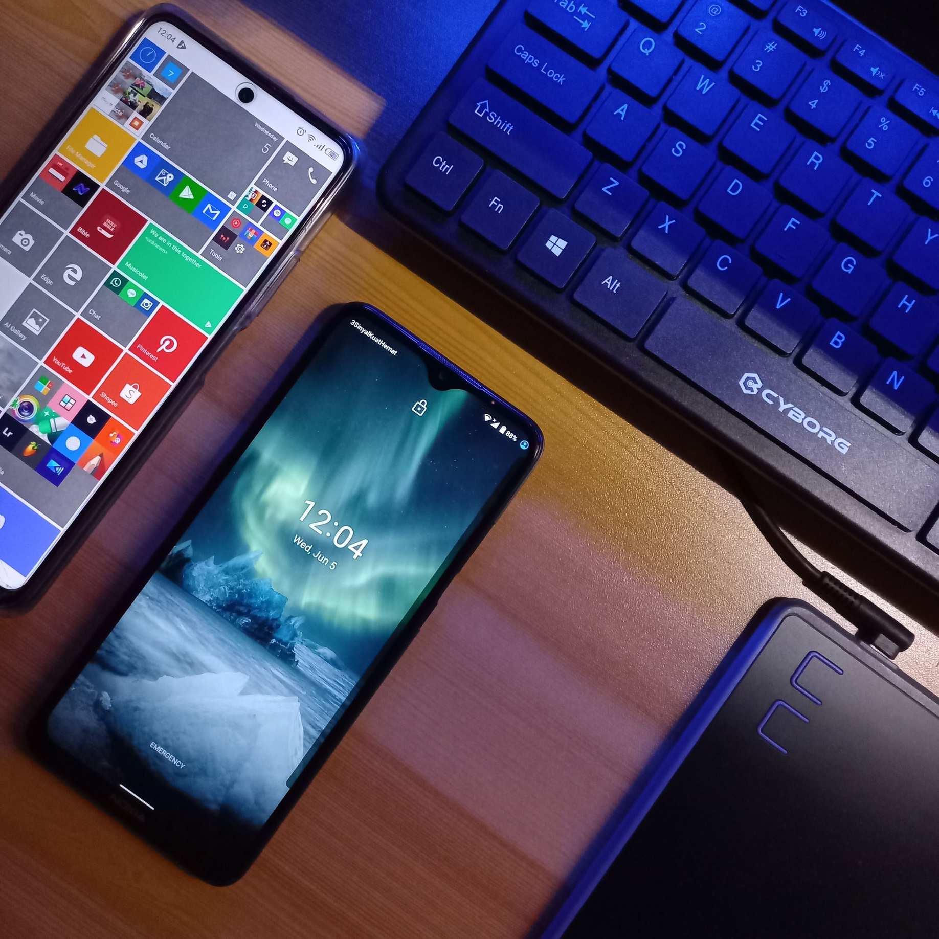 Keyboard and smartphones on a wooden desk